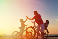 Biker family silhouette, father with two kids on bikes
