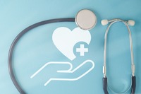 Hand die Herz hält mit einem Stethoskop. Zeigt ein Bild mit einer Hand die Herz hält mit einem Stethoskop.