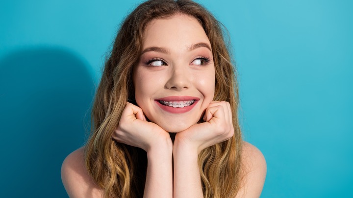 Junge Frau lächelt und zeigt ihre Zahnspange